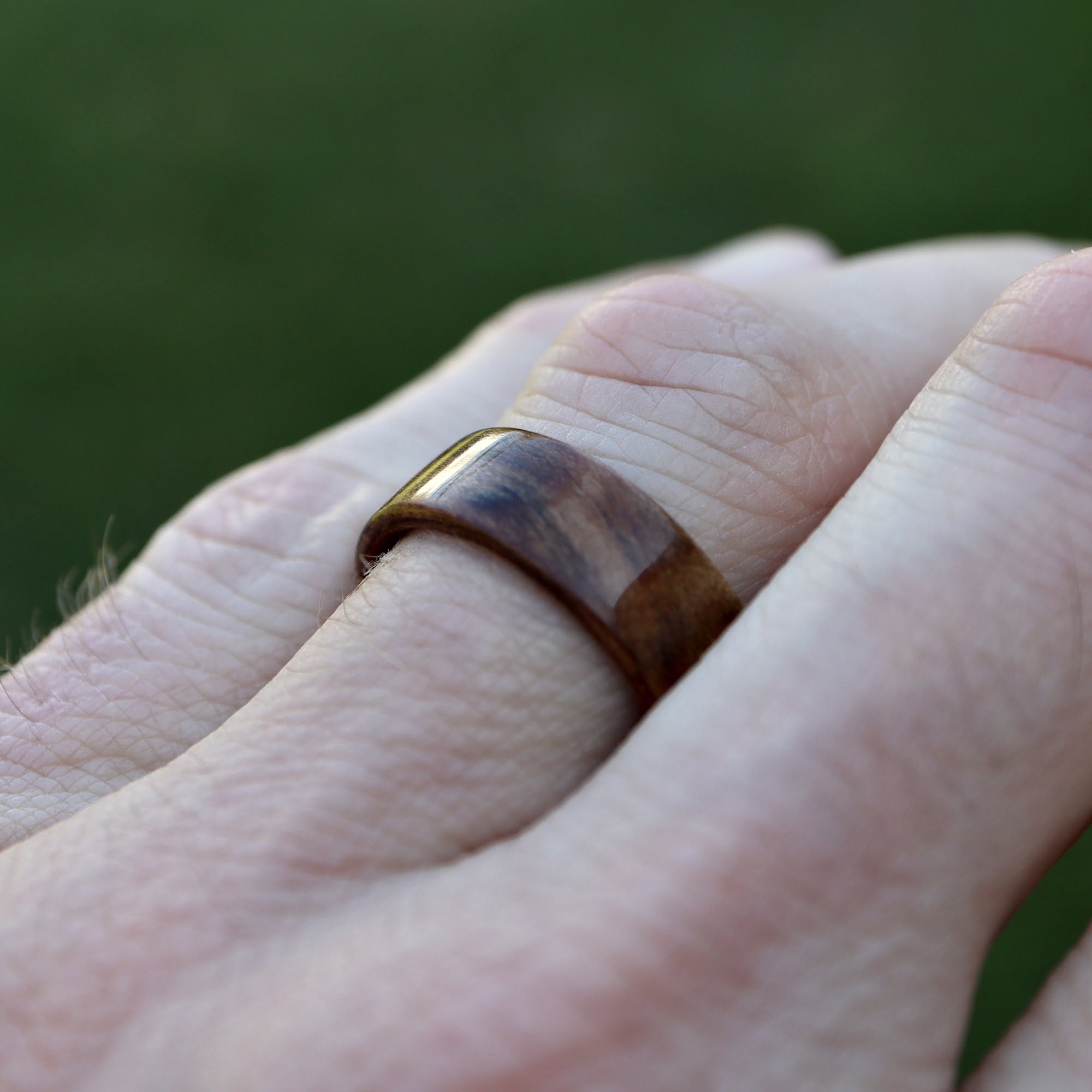 Black Heart Sassafras Wooden Ring on Hand Grass background